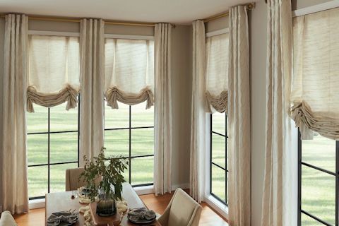 Horizons Soft Treatments Soft Pleated London Shades in Providence, Natural with Back Tab Drapery in Courage Swordsman Moonlight and Treasures Drapery Hardware in Matte Gold